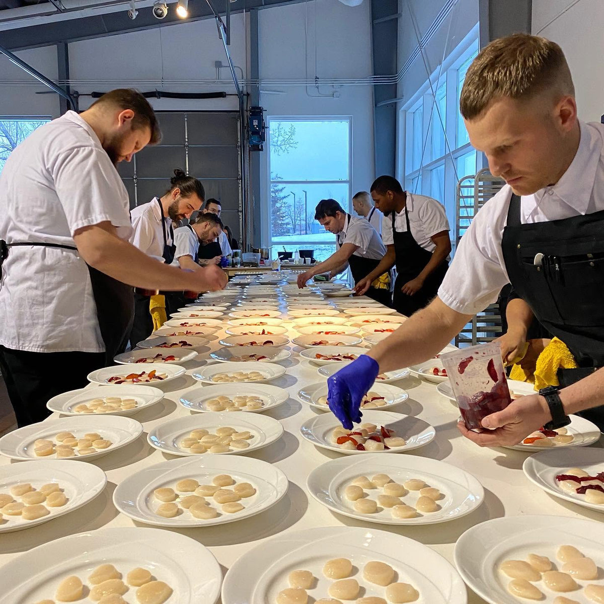 Chefs finishing plates in the kitchen
