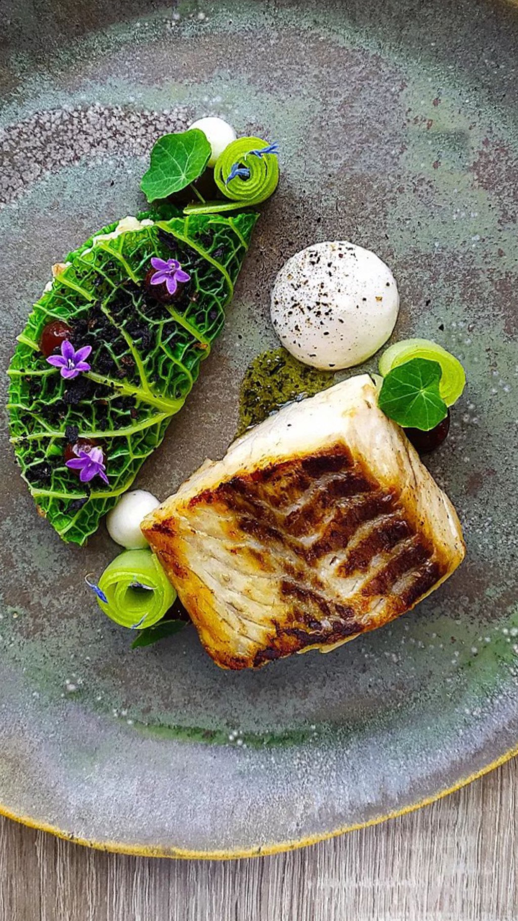 Seared halibut with edible flowers for a corporate dinner